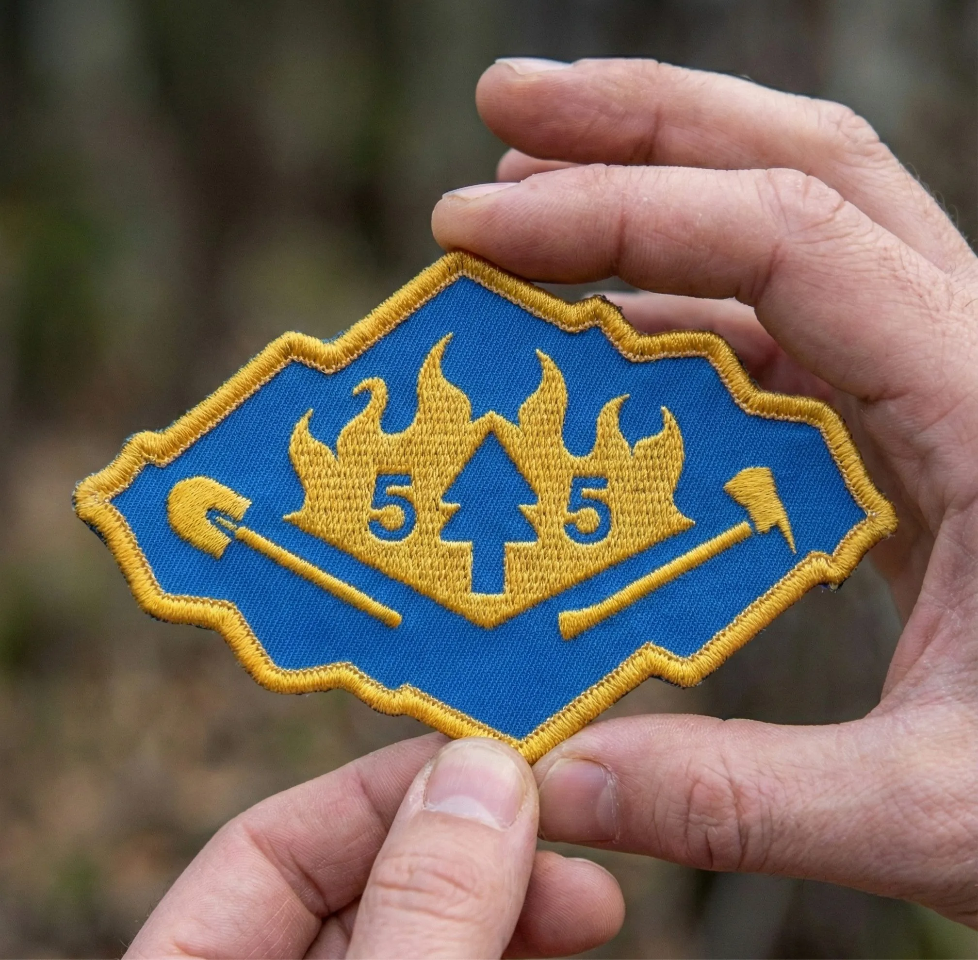 Embroidered Squad 55 patch held in a hand